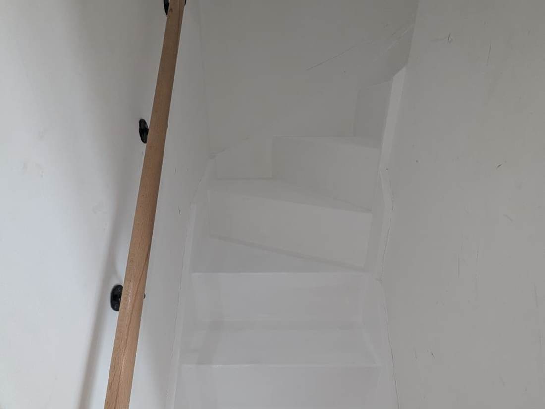 Freshly repainted white staircase and handrail inside a Manchester property